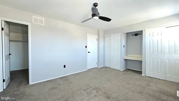 a view of an empty room with a ceiling fan