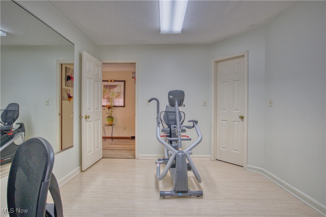 7017 Kirk Road Canfield, OH 44406 - Photo 27 of 35 Exercise area with light wood finished floors and a textured ceiling
