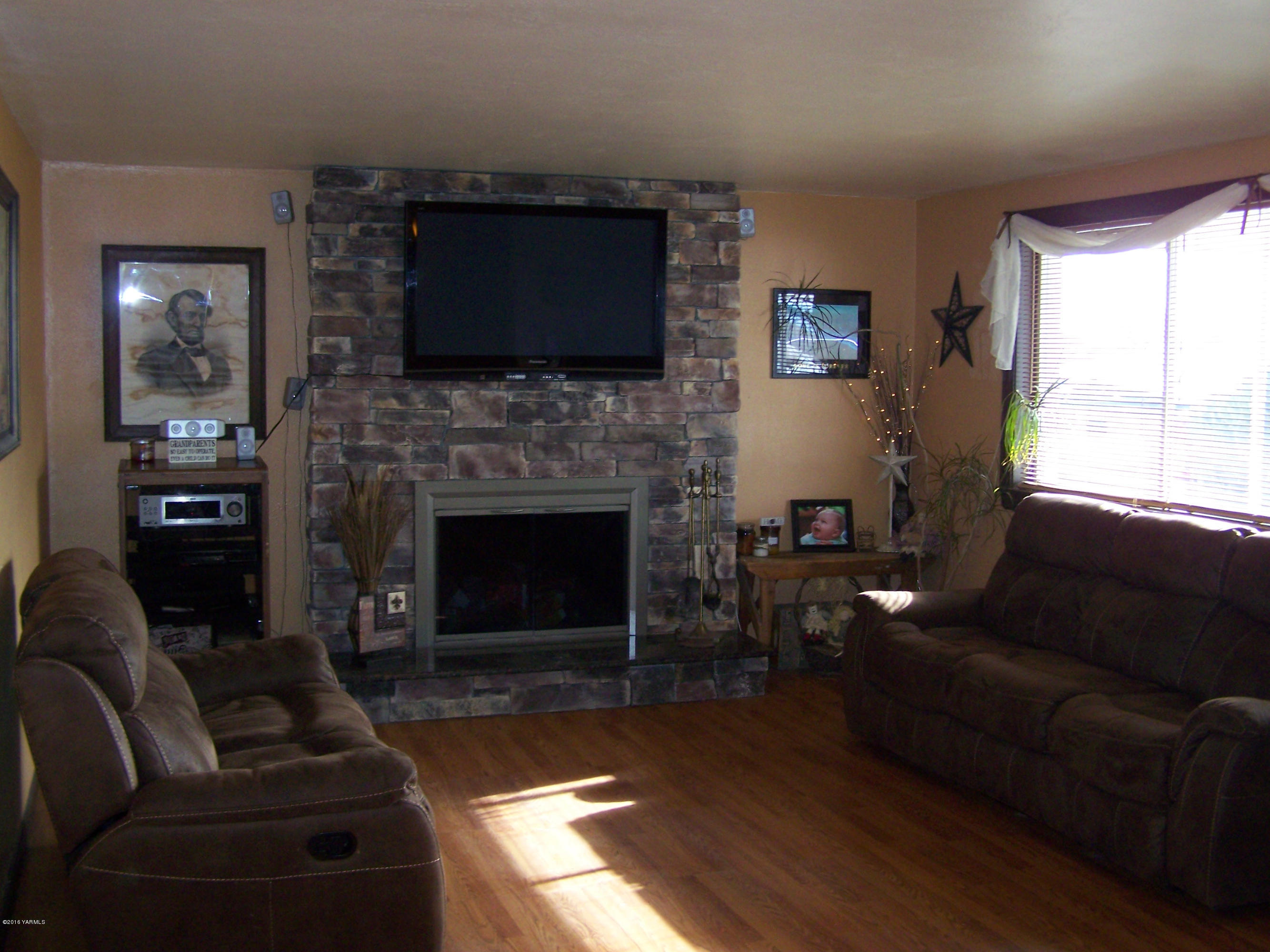 11203 Summitview Ext Road Yakima, WA 98908 - Photo 3 of 33 a living room with furniture a flat screen tv and a fireplace