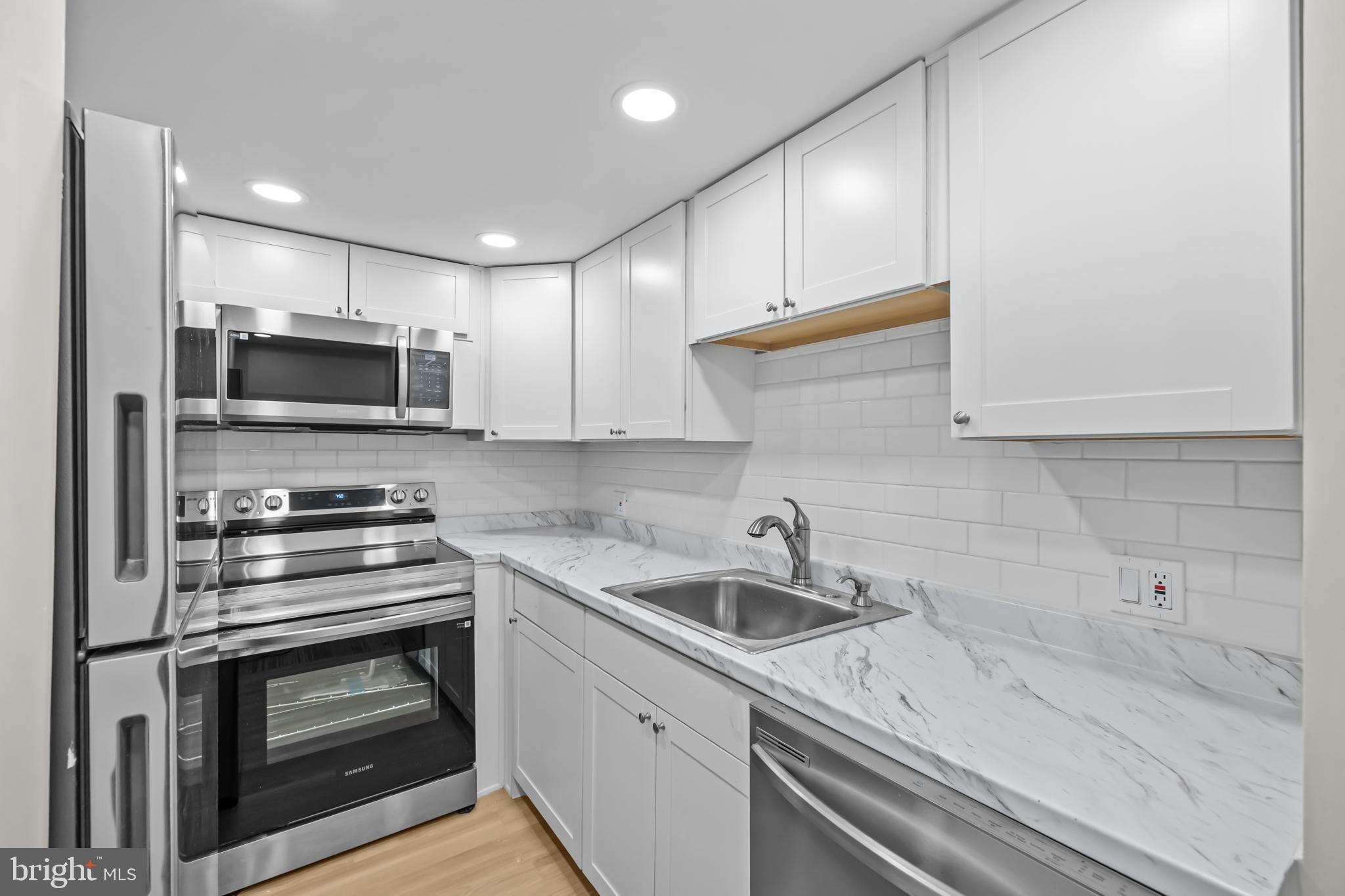 1615 Q Street Northwest, Unit T1 Washington, DC 20009 - Photo 9 of 42 a kitchen with a sink stove and microwave