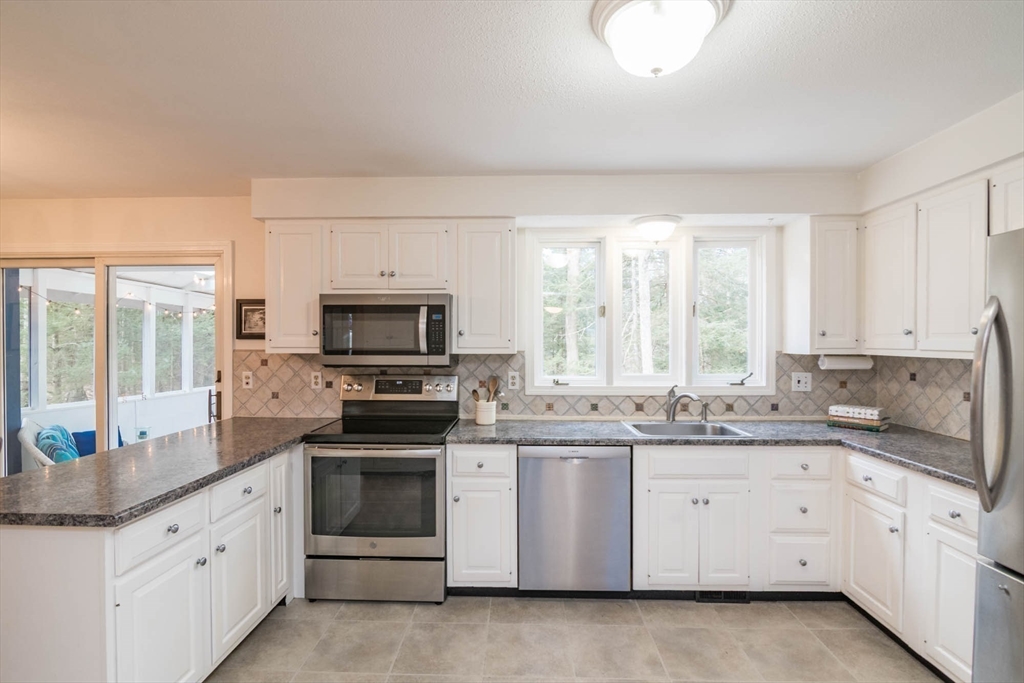 171 Aubinwood Road Amherst, MA 01002 - Photo 15 of 42 a kitchen with stainless steel appliances granite countertop white cabinets a sink a stove and a granite counter tops