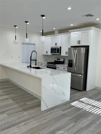 a kitchen with stainless steel appliances a refrigerator sink and microwave