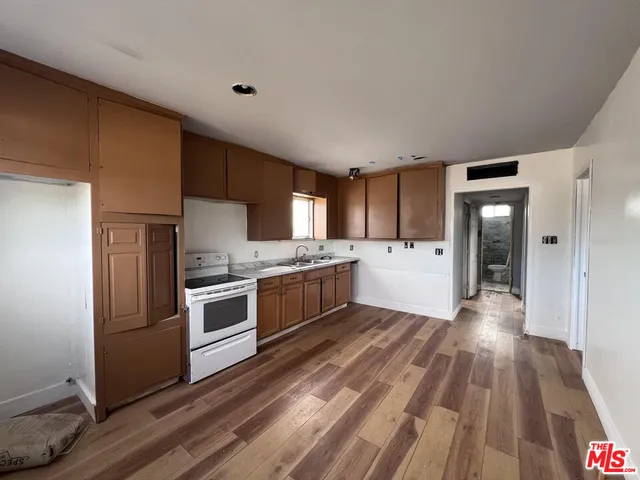 a kitchen with granite countertop a refrigerator and a stove top oven