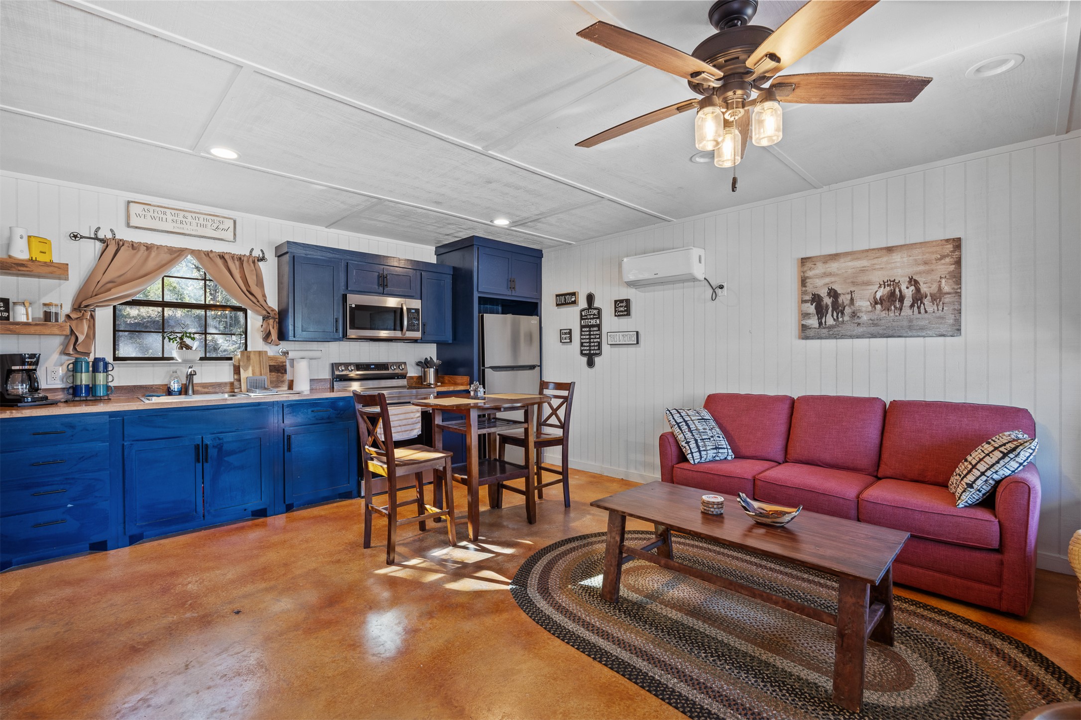 641 Patterson Creek Road Leakey, TX 78873 - Photo 29 of 37 Living area with concrete flooring, ceiling fan, and wood walls