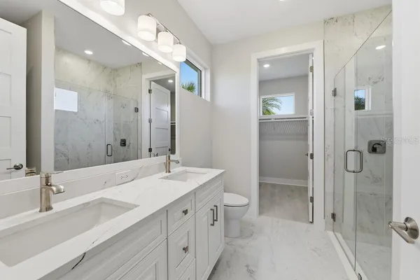 a bathroom with a double vanity sink mirror double and shower