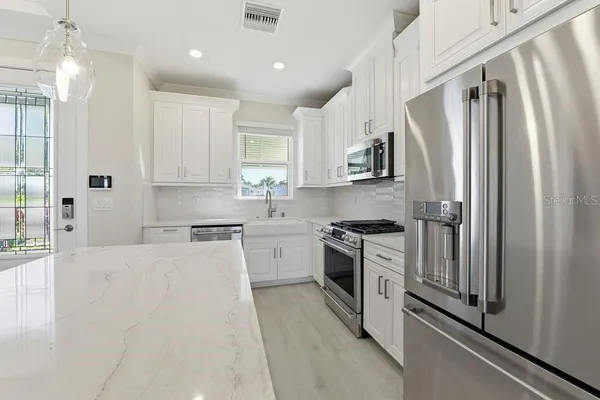 a kitchen with stainless steel appliances granite countertop a refrigerator sink and stove