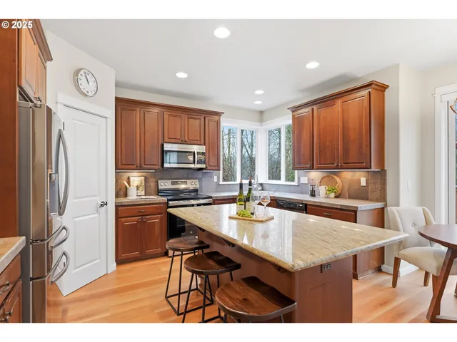 a kitchen with stainless steel appliances granite countertop a stove refrigerator sink and cabinets