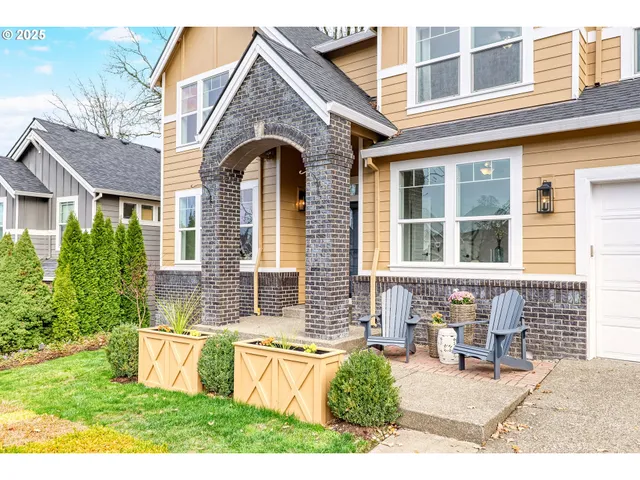 a front view of a house with barbeque and wooden fence