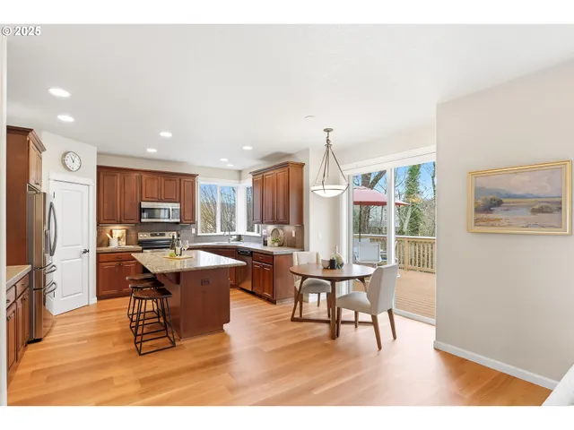 a living room with furniture a large window and stainless steel appliances