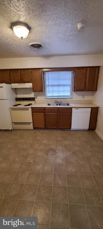 a view of kitchen with stainless steel appliances cabinets and stove top oven