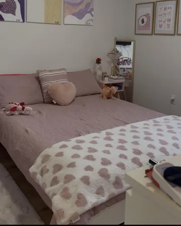 a bedroom with a bed and teddy bear on dresser