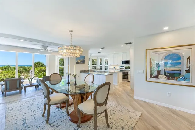 a view of a dining room with furniture a chandelier and wooden floor