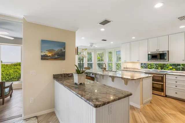 a kitchen with stainless steel appliances granite countertop a stove top oven a sink and dishwasher with wooden floor