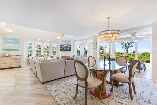 a dining room with furniture a chandelier and wooden floor