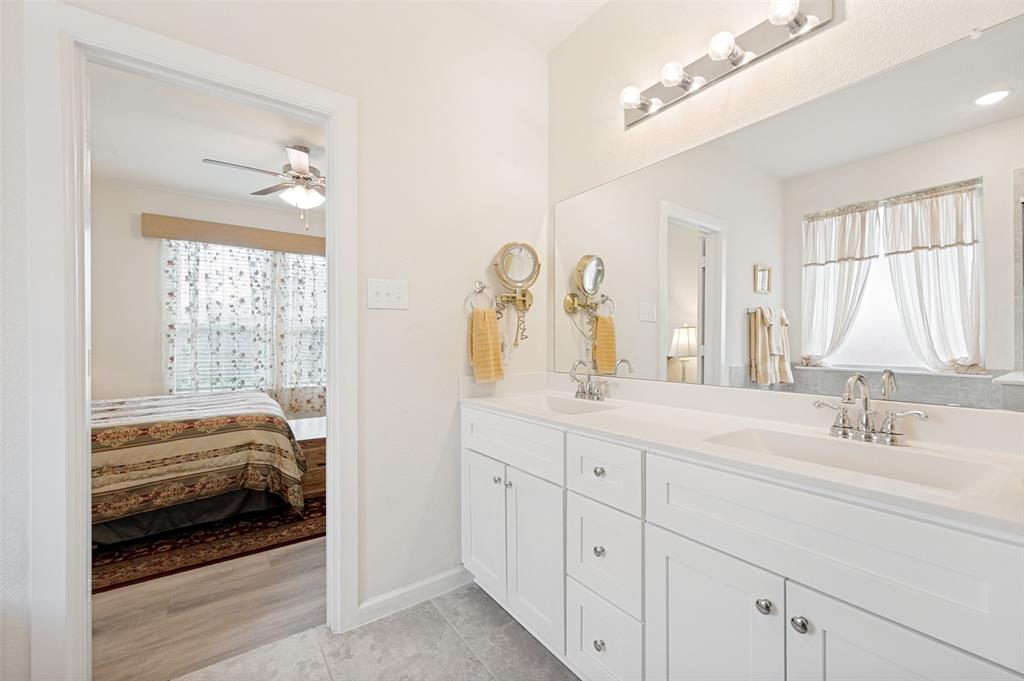 413 Wiggins Way Van Alstyne, TX 75495 - Photo 18 of 25 Double vanity with white cabinetry, integrated sinks, chrome fixtures, and a full-width mirror