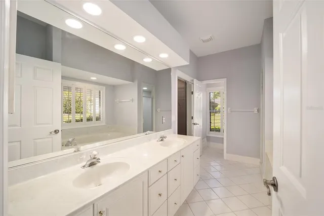 a spacious bathroom with a double vanity sink mirror and shower