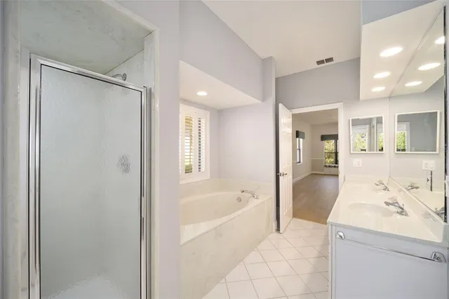 a large white bathroom with a bathtub and a sink