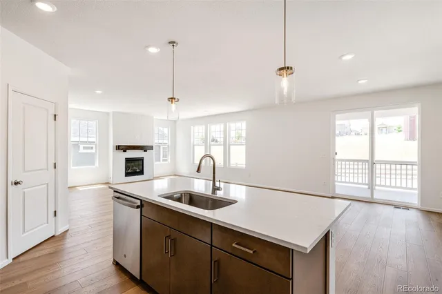 a large kitchen with stainless steel appliances granite countertop a large counter top and a stove top oven with wooden floor