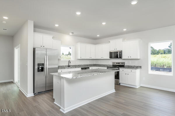 64 Foxton Place Angier, NC 27501 - Photo 13 of 26 a kitchen with stainless steel appliances granite countertop a stove top oven a refrigerator a sink and a microwave with wooden floor
