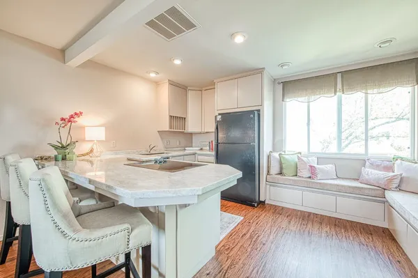 a kitchen with a table chairs refrigerator and couch