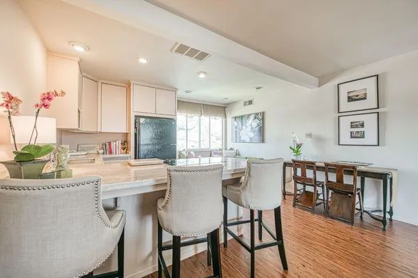 a kitchen with stainless steel appliances granite countertop a dining table chairs and sink