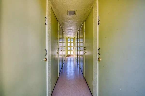 a view of a hallway with wooden floor and staircase