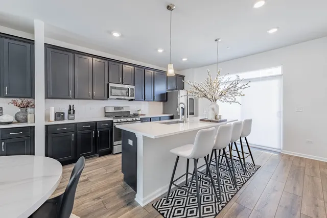 a kitchen with a table chairs microwave and cabinets