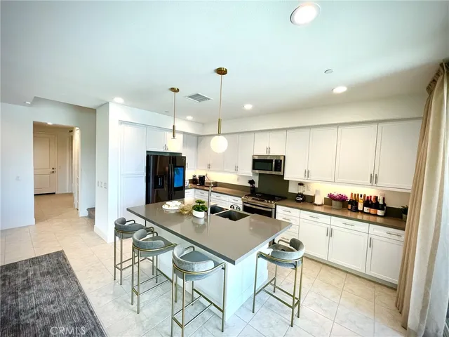 a kitchen with a dining table chairs and a refrigerator