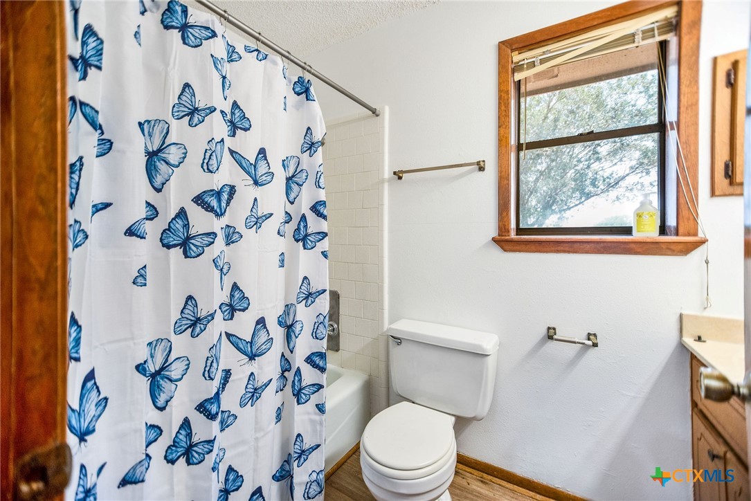 181 Pecan Street Port Lavaca, TX 77979 - Photo 20 of 34 a white toilet sitting next to a shower curtain
