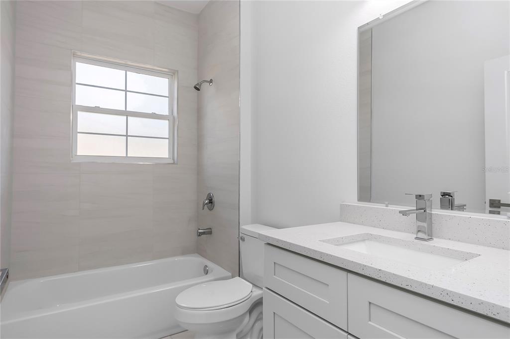 15070 Southwest 21st Ter Road Ocala, FL 34473 - Photo 30 of 47 a bathroom with a granite countertop sink a toilet and shower