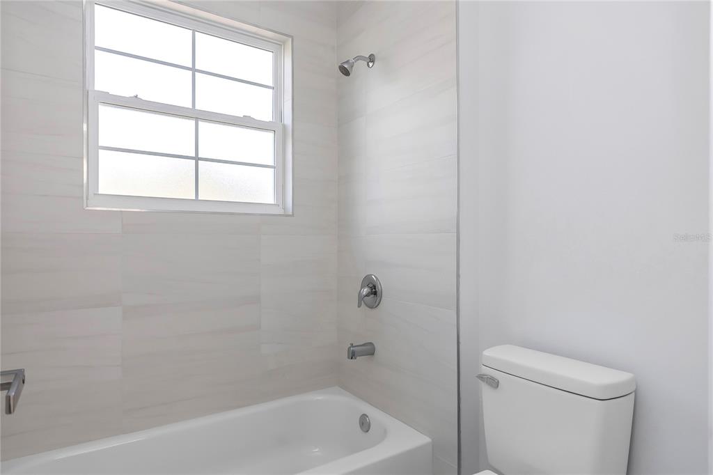 15070 Southwest 21st Ter Road Ocala, FL 34473 - Photo 34 of 47 a bath room with a toilet a bath tub and a window