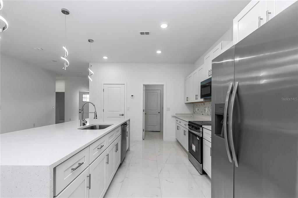 15070 Southwest 21st Ter Road Ocala, FL 34473 - Photo 45 of 47 a kitchen with stainless steel appliances kitchen island granite countertop a sink and cabinets