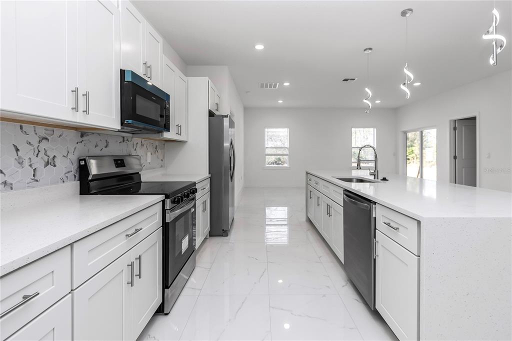 15070 Southwest 21st Ter Road Ocala, FL 34473 - Photo 7 of 47 a large kitchen with stainless steel appliances lots of counter space sink and cabinets