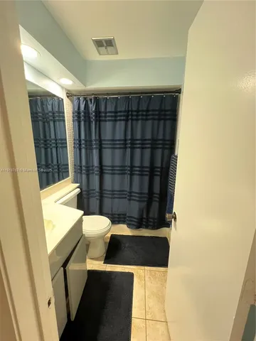 a bathroom with a toilet and a shower curtain