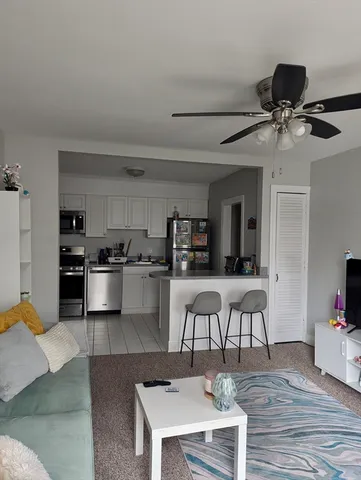 a living room with furniture and a kitchen view