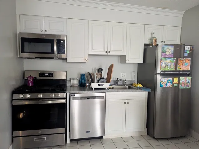 a kitchen with stainless steel appliances granite countertop a stove a refrigerator and a microwave