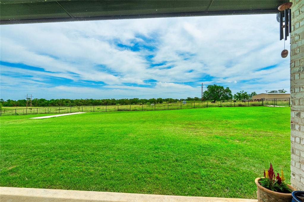 1024 Henry Way Springtown, TX 76082 - Photo 4 of 29 Expansive green lawn with a perimeter fence, offering broad outdoor space