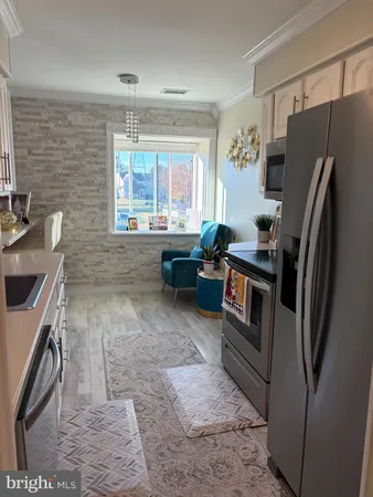 a kitchen with granite countertop a refrigerator a sink a stove and washer