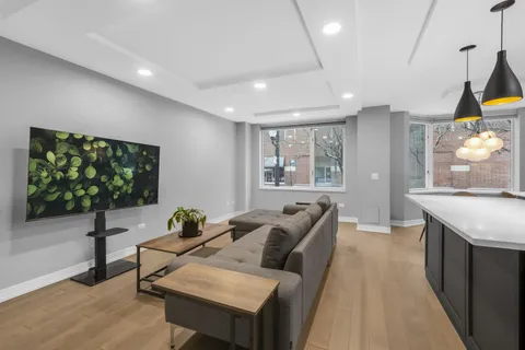 a living room with furniture a window and a flat screen tv