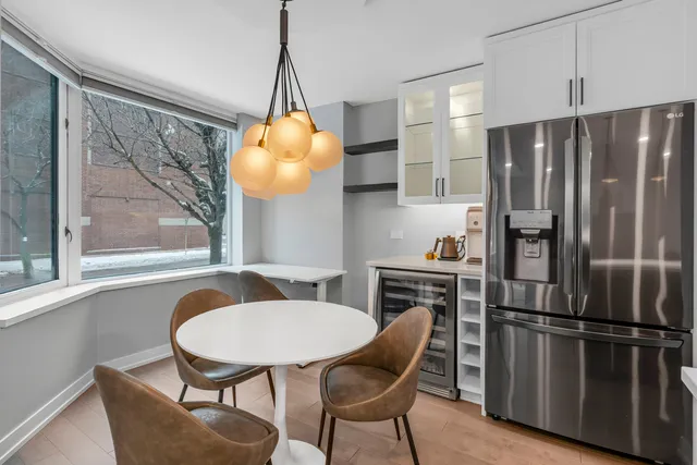 a kitchen with stainless steel appliances a dining table chairs and chandelier
