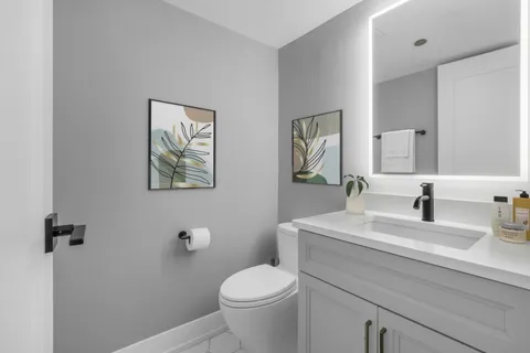 a bathroom with a granite countertop toilet sink and mirror