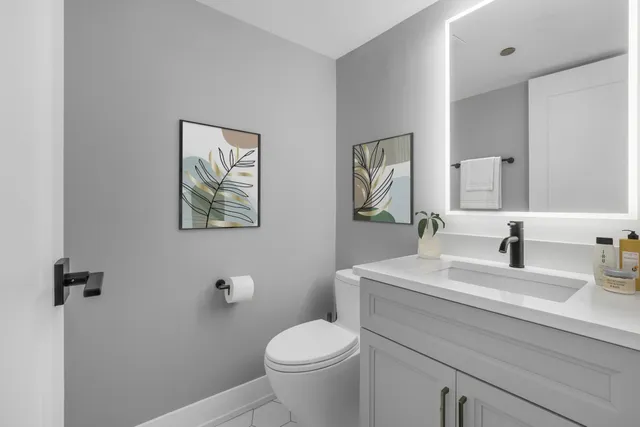 a bathroom with a granite countertop toilet sink and mirror
