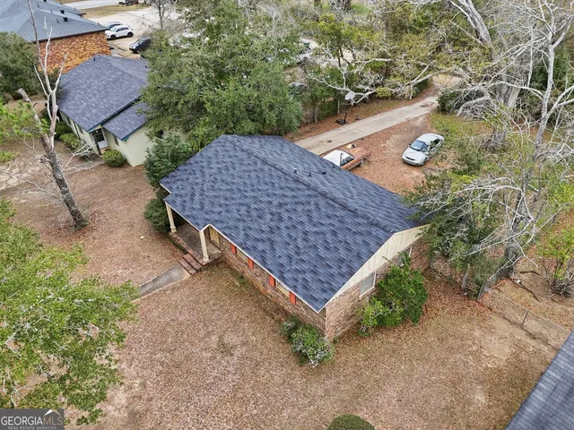 an aerial view of a house with a yard and wooden fence