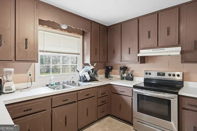 a kitchen with a sink stove and cabinets