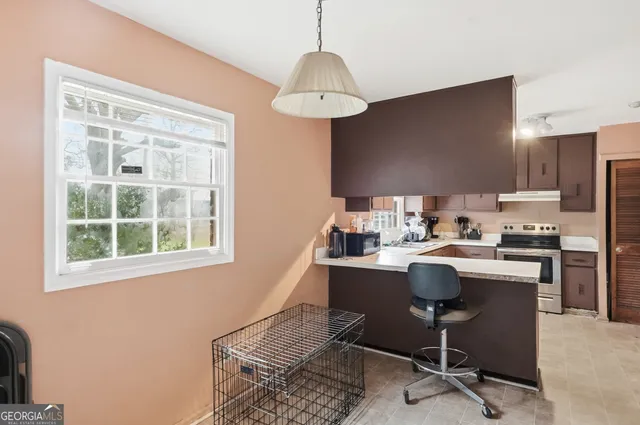 a view of a workspace with furniture and a window