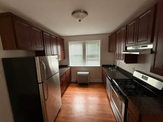 a kitchen with stainless steel appliances wooden cabinets and a stove