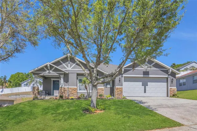 a front view of a house with a garden and trees