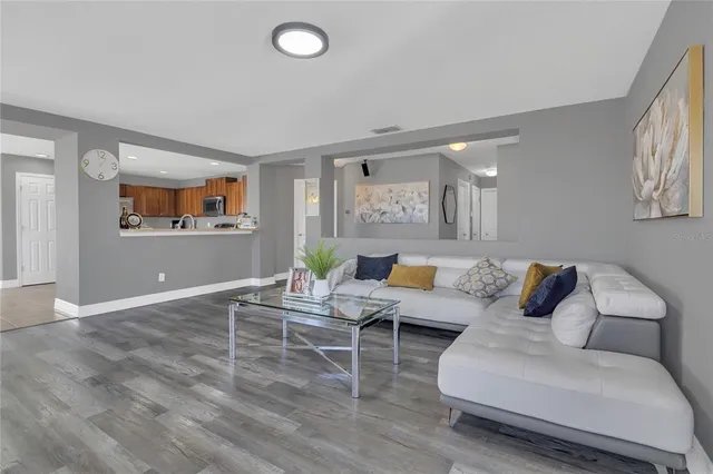 a living room with furniture and a wooden floor