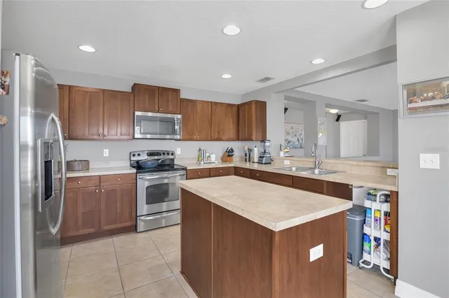 a kitchen with stainless steel appliances granite countertop a refrigerator sink and cabinets
