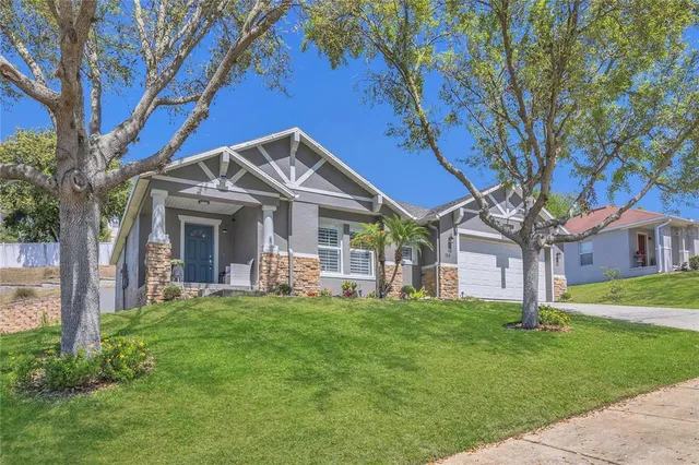 a front view of a house with a garden and trees